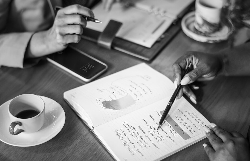 Image of two women in a meeting reviewing notes and discussing changes that need to be made to a West Virginia irrevocable trust.