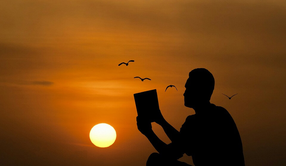 Image of a silhouetted person reading at sunset, representing how attorney Oscar R. Molina can help nonimmigrant students can obtain a US student visa to study at a West Virginia university.