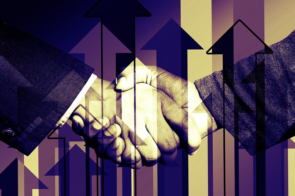 Image of shaking hands overlaid with arrows pointing up, representing how attorneys guides businesses in using mergers and acquisitions as a growth strategy.