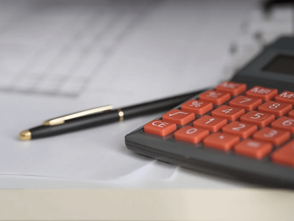 Image of a calculator and pen on accounting paperwork, representing how PPP loan forgiveness guidance is available at Jenkins Fenstermaker, PLLC.