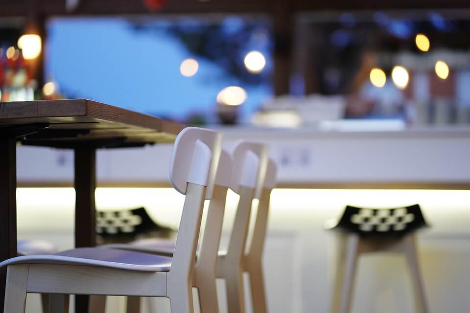An image of empty chairs at a restaurant, representing how hospitality industry attorney Xavier W. Staggs explains how hospitality businesses are surviving the pandemic and the sad fact that some are not.