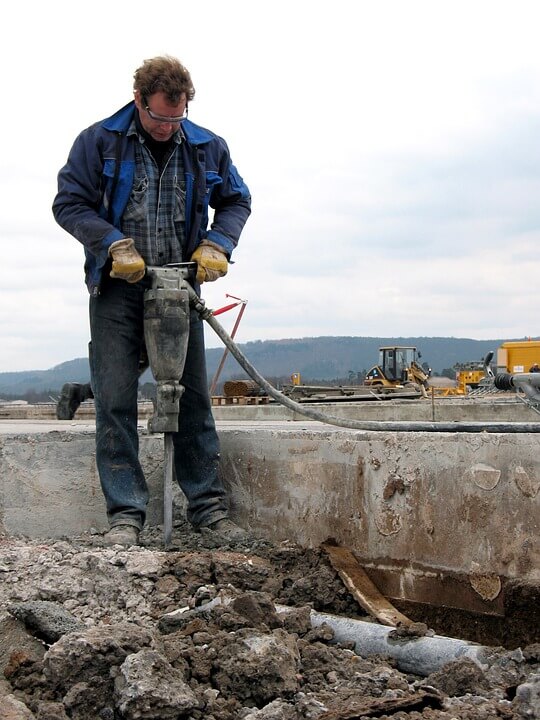 Image of a man jackhammering on a road construction crew, creating respirable dust, representing the type of activities regulated by OSHA to minimize worker exposure to crystalline silica and construction site standards that Jenkins Fenstermaker’s attorneys can help you understand.