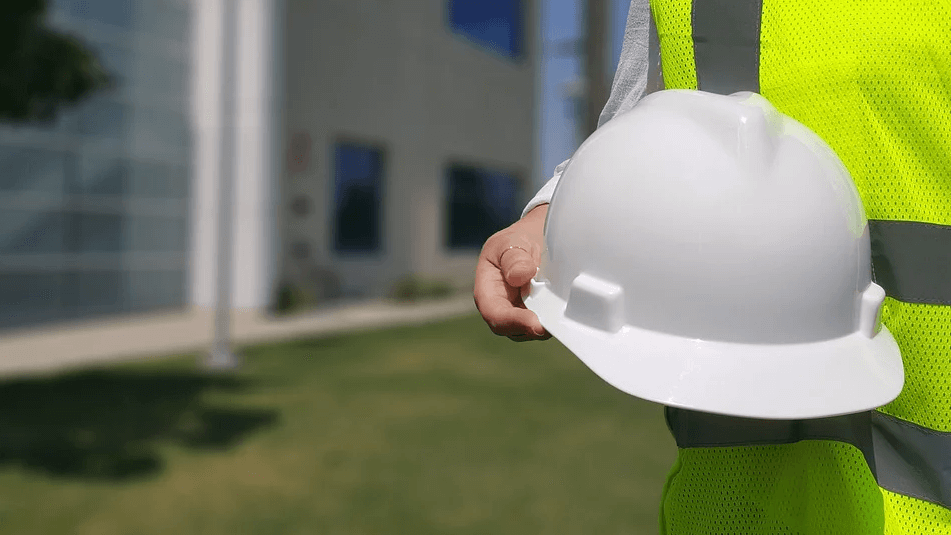 Image of a man wearing a safety vest and holding a hard hat, representing the impact of the West Virginia right to work law on employees, employers, and unions.