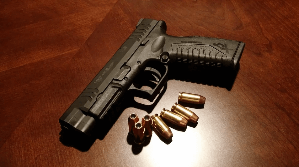 An image of a handgun and ammunition, representing the need for gun owners to know gun license reciprocity and concealed carry laws, especially when traveling through or to other states, even if they’ve planned ahead with a gun trust.