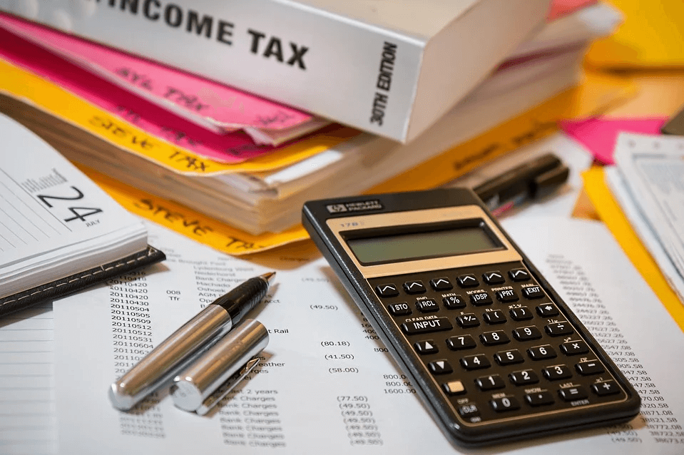 Image of a calculator next to tax records and files, representing how West Virginia employer lawyers at Jenkins Fenstermaker help employers navigate the FFCRA paid leave tax credit requirements.