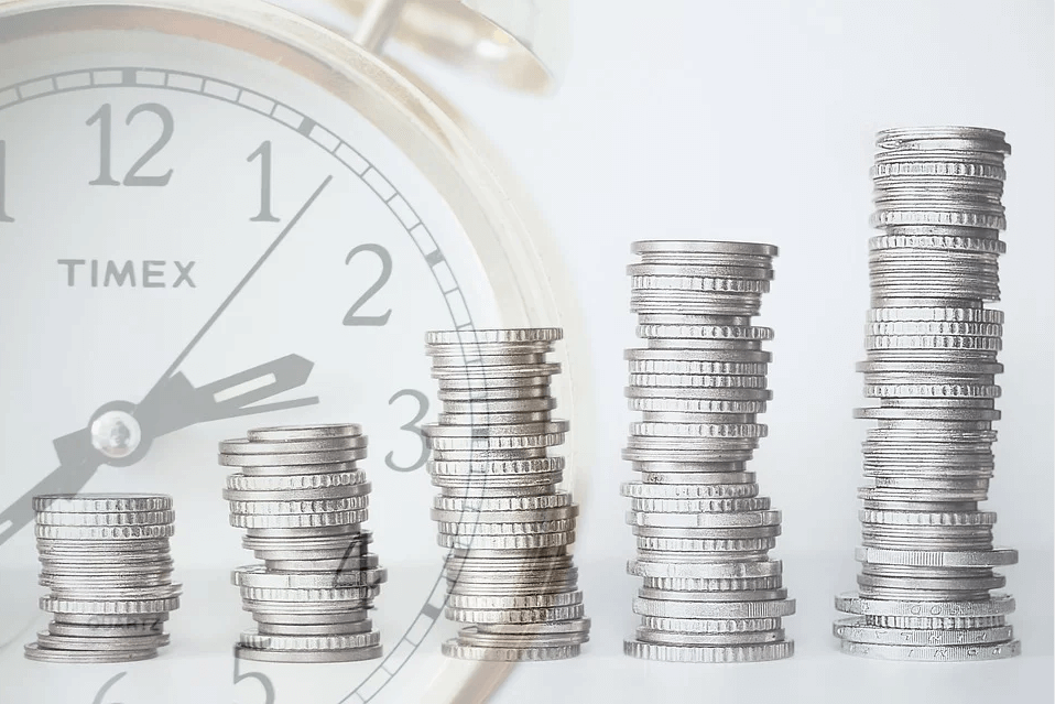 Image of coins stacked in front of a clock, representing what you need to know when putting an IRA in your WV estate plan and how attorney Anna M. Price of Jenkins Fenstermaker, PLLC, can help with estate planning in WV.