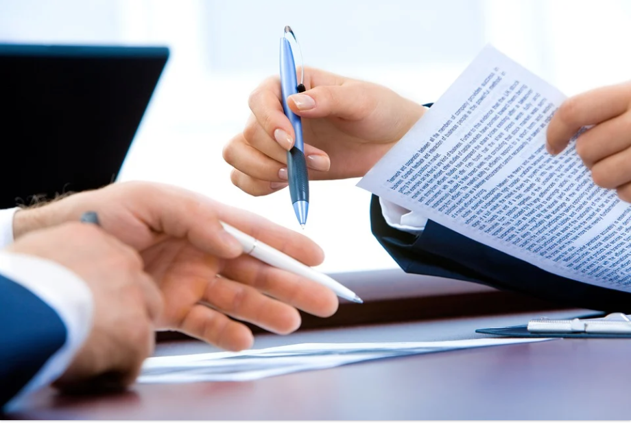 Image of two attorneys reviewing documents by a laptop, representing how the tristate appellate lawyers at Jenkins Fenstermaker, PLLC provide in-depth experience and dedication to all appellate clients.