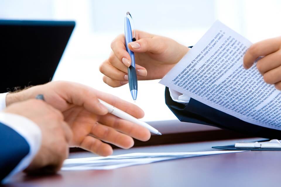 Two sets of hands holding pens and paperwork, representing the experience and work ethic of the tristate insurance defense attorneys of Jenkins Fenstermaker, PLLC.
