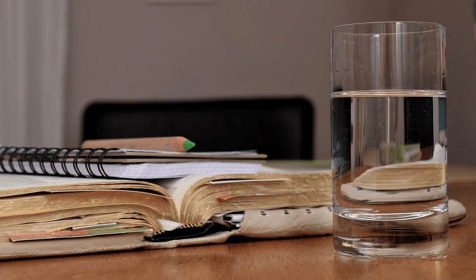 Image of notebooks and a glass of water, representing how Anna M. Price can help non-lawyers identify and perform the duties of an executor in WV, KY, and OH. 