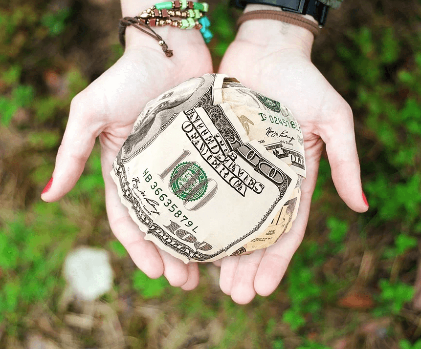 Image of two open hands holding a ball of cash, representing how family foundation attorney Anna M. Price at Jenkins Fenstermaker, PLLC helps those seeking to give back in WV, KY, and OH establish family foundations.