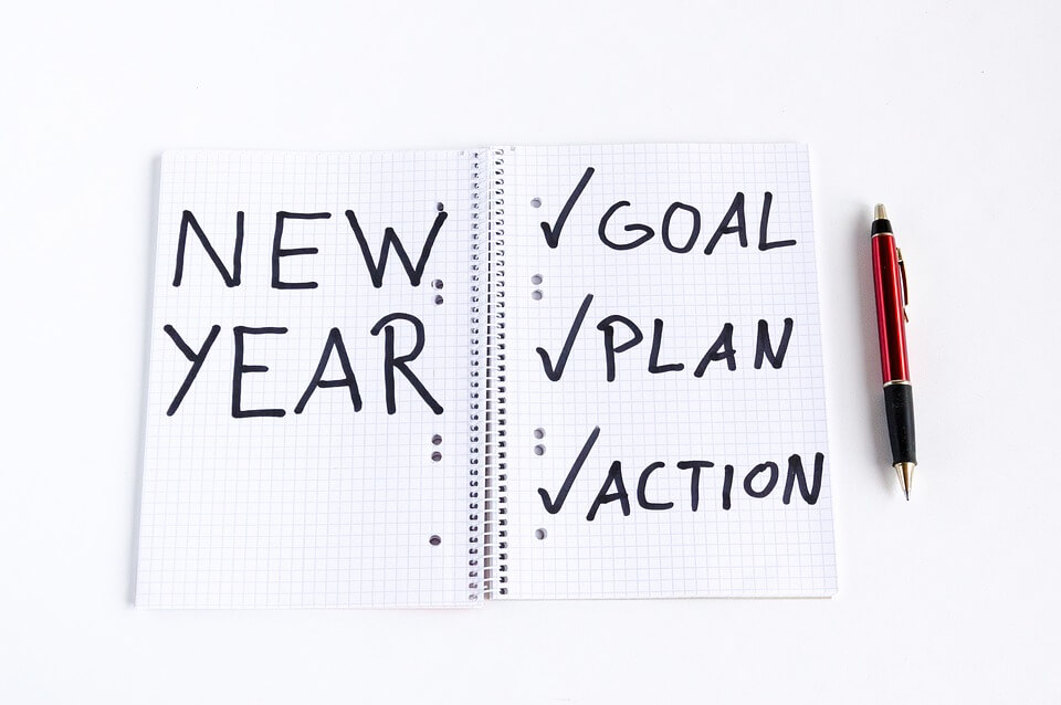 An image of a notebook with the words “new year” and “goal, plan, action,” representing the New Year’s resolution of setting estate planning goals for the year ahead.