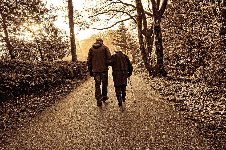 An image of an elderly couple walking a wooded path, representing the need to include long-term care and spousal Medicaid considerations in estate and elder care planning and how Jenkins Fenstermaker’s estate planning attorneys can help in WV, KY, and OH.