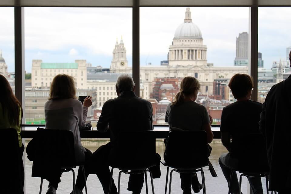 Silhouette of co-workers sitting at a window looking outside, representing the diversity of employees and how an experienced attorney can help employers understand their responsibilities regarding sexual orientation discrimination in the workplace in WV.