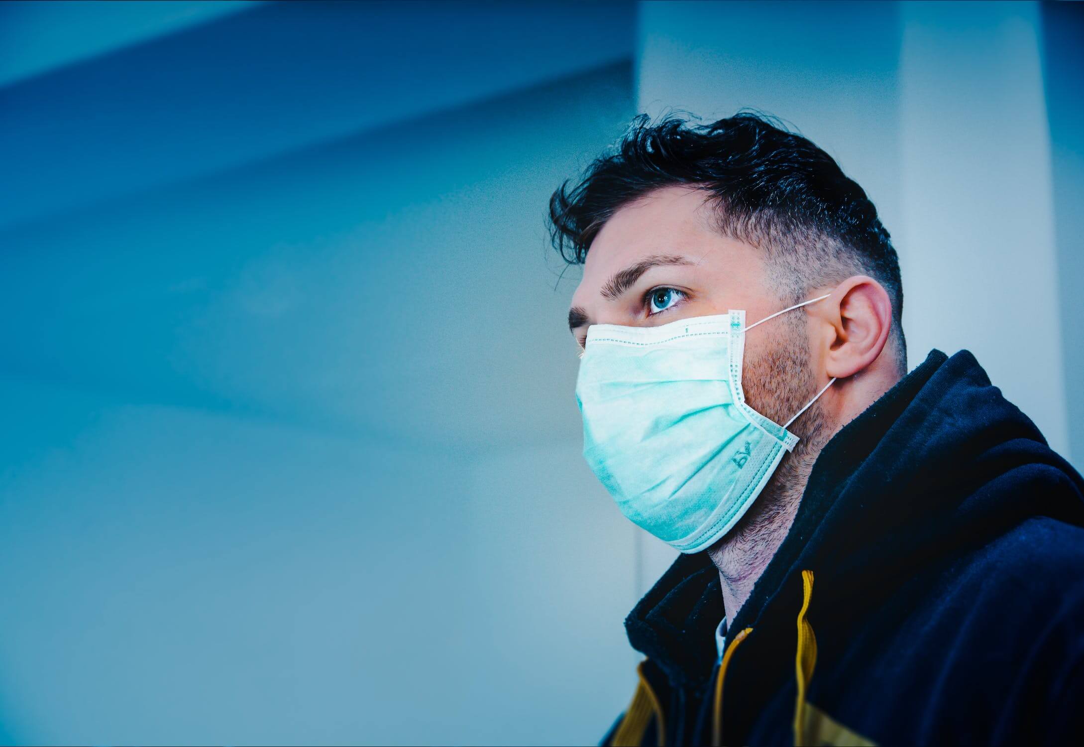 Image of a man wearing a medical paper mask, representing how West Virginia employer lawyers Gary Matthews and Michael Frye help employers understand court decisions and federal regulations interpreting the FFCRA.