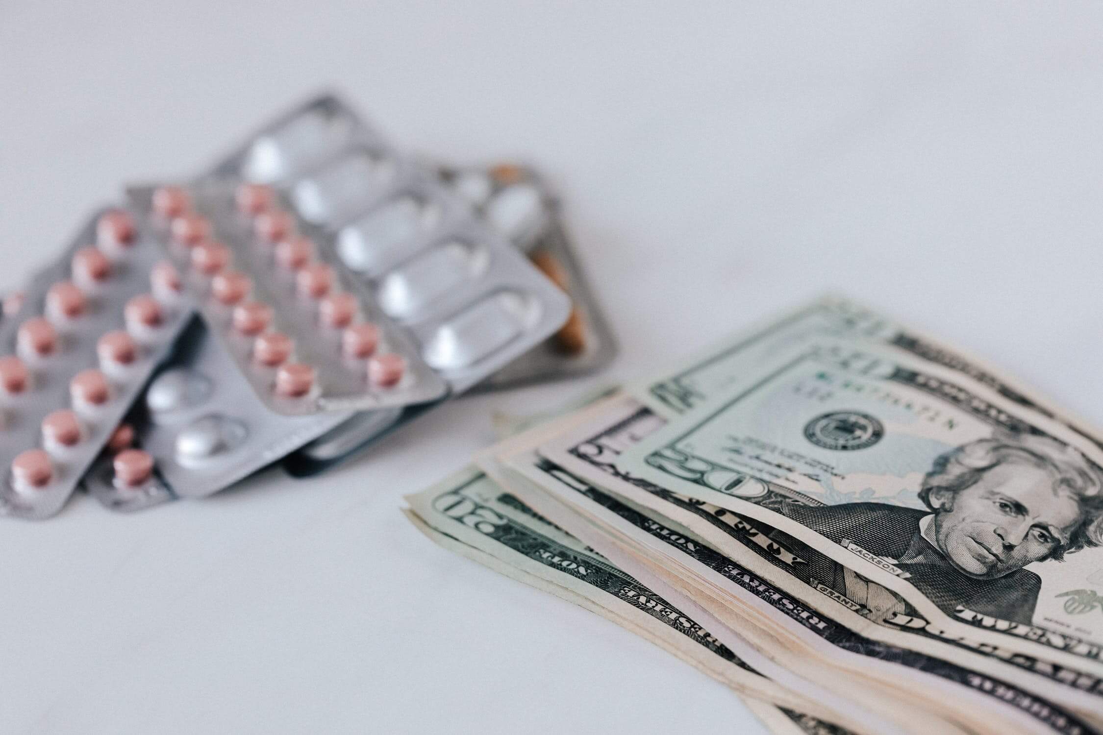 Image of pill-packs and US dollars, representing how employer lawyers at Jenkins Fenstermaker help WV companies navigate FFCRA employer paid leave requirements.