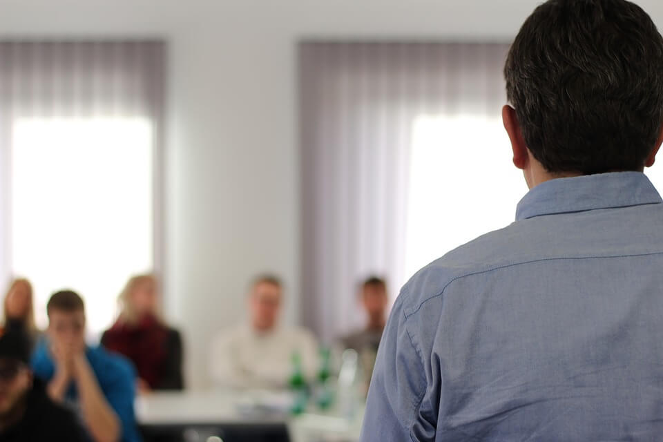 Image of a man speaking in front of a room full of students, representing the vital information that your employees can gain from one of Jenkins Fenstermaker's speakers on WV law.