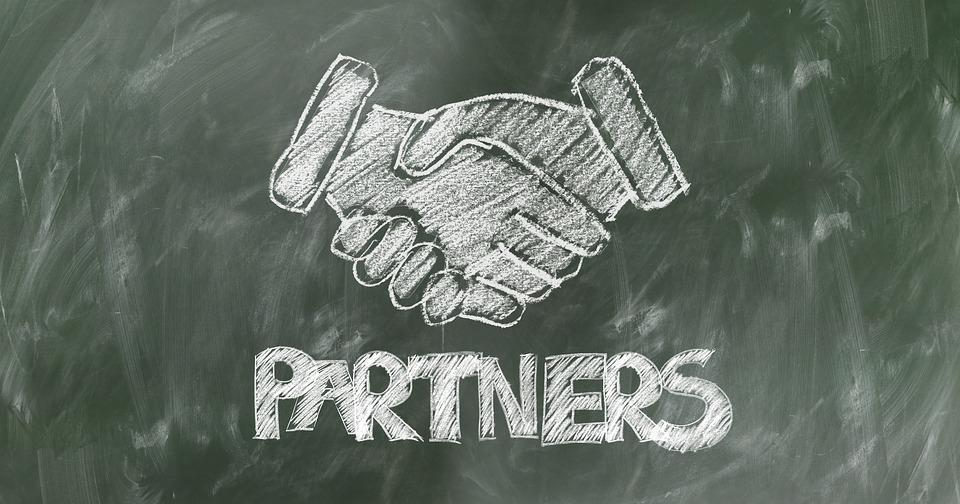 A chalk image of shaking hands and the word “partners” written on a chalkboard, representing the partnership out-of-state attorneys can form with a WV local counsel from Jenkins Fenstermaker in West Virginia.