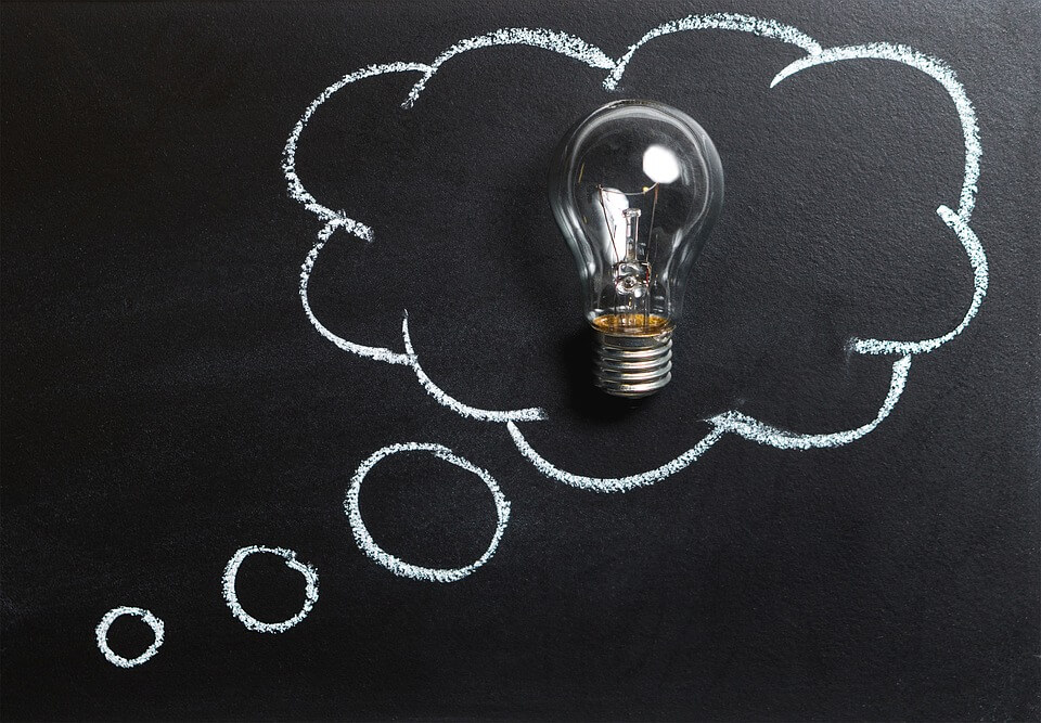 Image of a chalkboard displaying a light bulb surrounded by a cloud, symbolizing thinking about all potential outcomes of a business ownership transition in WV, KY, or OH.