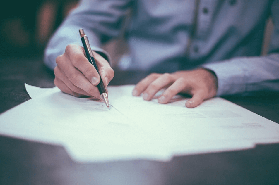 Image of a client signing trust documents, representing a person who worked with a trust lawyer in WV to determine the best trust documents to complete their estate plan.